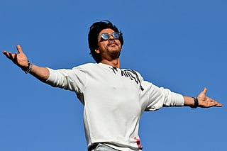 Bollywood actor Shah Rukh Khan greets fans with his iconic pose at his residence Mannat in Mumbai on June 10, 2023.